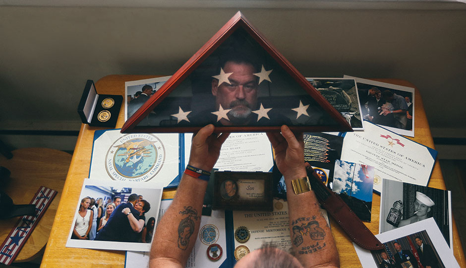 Charlie Strange holds the flag given to him by the military after his son's death. Photography by Neal Santos