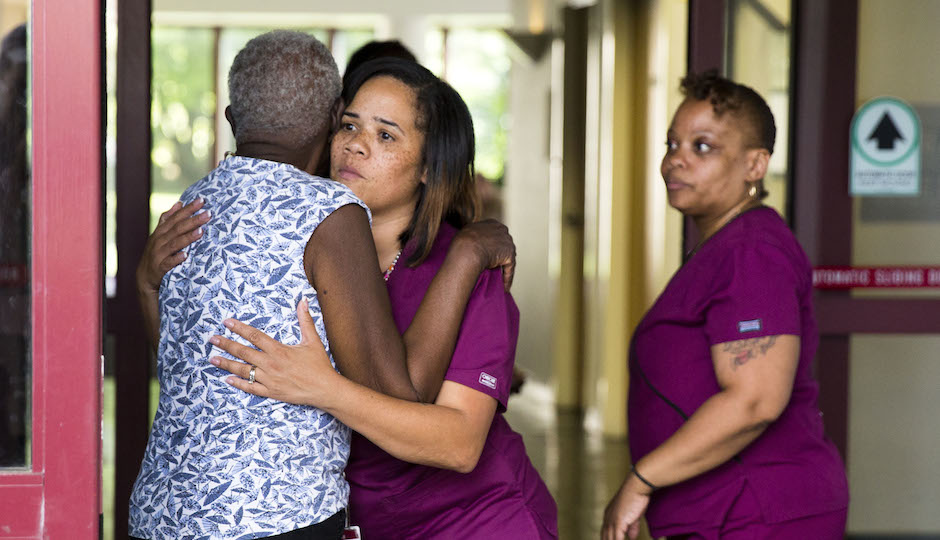 A hospital worker embraces a woman near the scene of a shooting at the Mercy Fitzgerald Hospital in Darby, Pa. on Thursday, July 24, 2014. A prosecutor said a gunman opened fire inside the psychiatric unit leaving one hospital employee dead and a second injured before being critically wounded himself. (AP Photo)