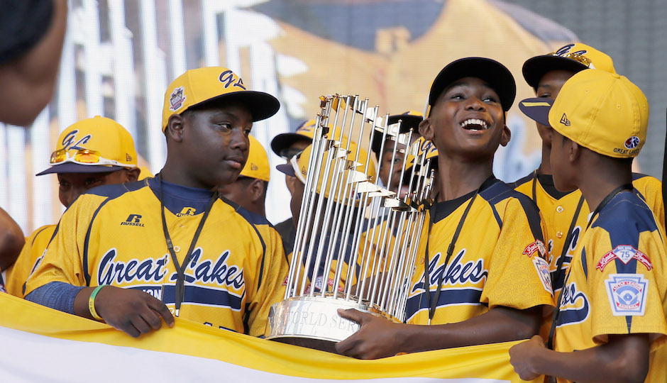 In this Aug. 27, 2014, file photo, members of the Jackie Robinson West Little League baseball team participate in a rally in Chicago celebrating the team's U.S. Little League Championship. Little League International has stripped Chicago's Jackie Robinson West team of its national title after finding the team falsified its boundary map. The league made the announcement Wednesday morning, Feb. 11, 2015, saying the Chicago team violated regulations by placing players on the team who didn’t qualify because they lived outside the team’s boundaries. Little League International also suspended Jackie Robinson West manager Darold Butler from league activity.(AP Photo/Charles Rex Arbogast, File)