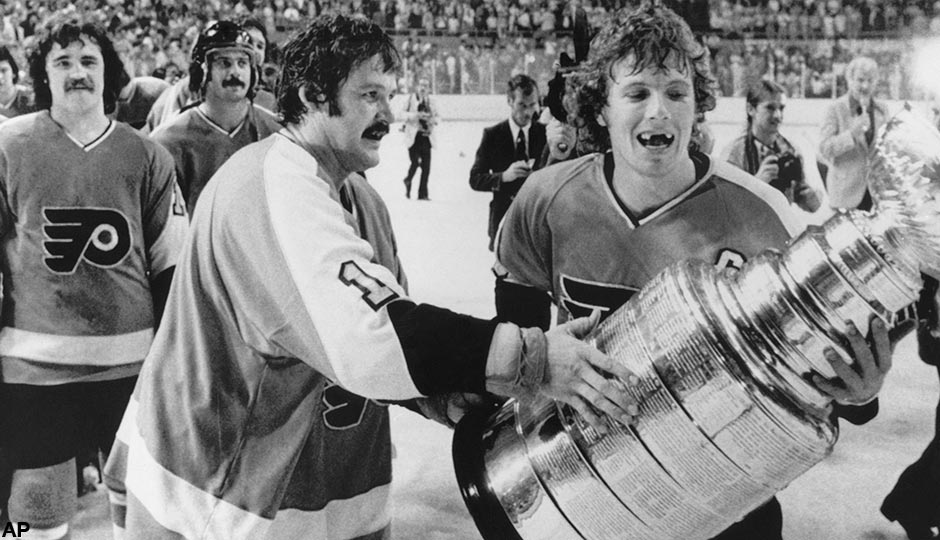 Philadelphia Flyers Bernie Parent, left, and Bobby Clarke, carry the Stanley Cup off the ice in Buffalo, May 27, 1975 after winning over the Buffalo Sabres. Score of the final game was 2-0.