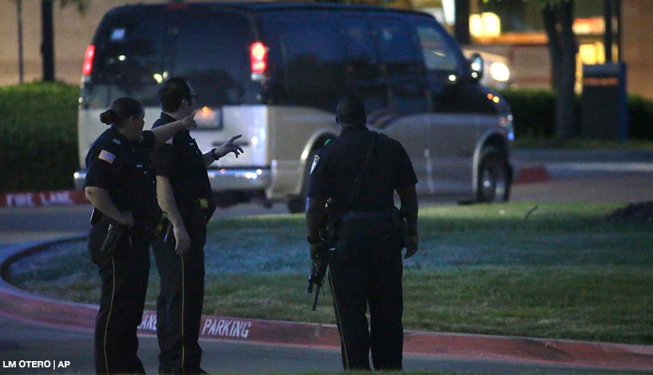 Police officers stands guard at a parking lot near the Curtis Culwell Center where a provocative contest for cartoon depictions of the Prophet Muhammad was held Sunday, May 3, 2015, in Garland, Texas. The contest was put on lockdown Sunday night and attendees were being evacuated after authorities reported a shooting outside the building. 