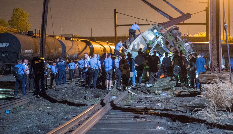 Emergency responders work on an overturned Amtrak car near tanker cars on May 12, 2015. Photograph by Bryan Woolston
