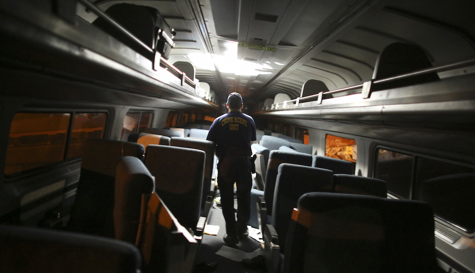 A crime scene investigator looks inside a train car after a train wreck, Tuesday, May 12, 2015, in Philadelphia. An Amtrak train headed to New York City derailed and crashed in Philadelphia. (AP Photo/Joseph Kaczmarek)