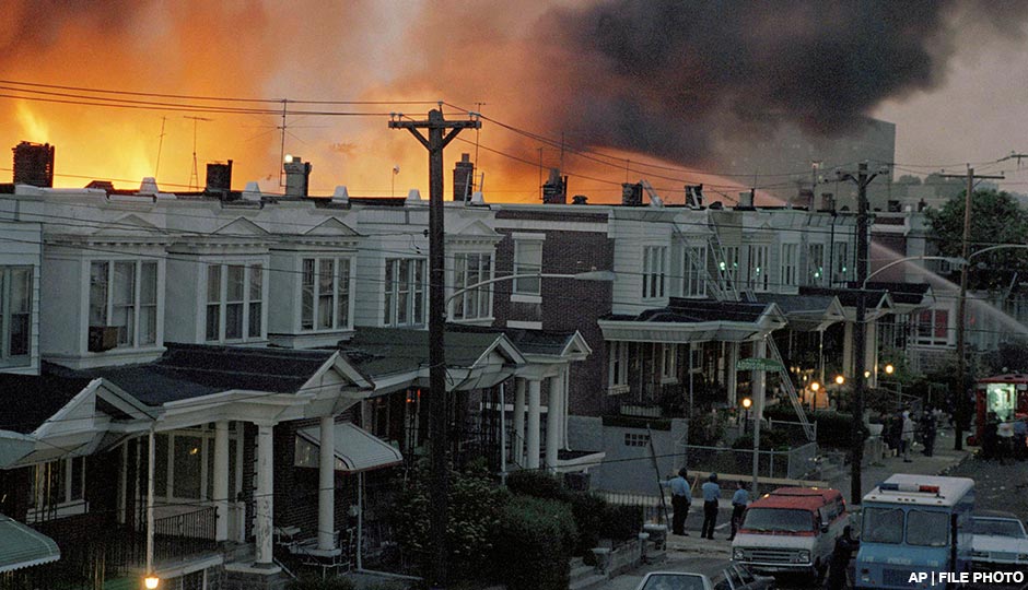 In this May 1985 photo, scores of row houses burn in a fire in the west Philadelphia neighborhood. Police dropped a bomb on the militant group MOVE's home on May 13, 1985 in an attempt to arrest members, leading to the burning of scores of homes in the neighborhood.
