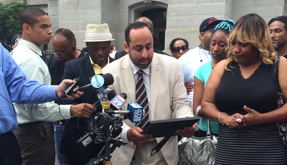 Brian Mildenberg, center, presents a "Certificate of Truth" to Tanya Brown-Dickerson Monday at City Hall. Mildenberg is representing Brown-Dickerson in a lawsuit over the death of her son, Brandon Tate-Brown. | Joel Mathis
