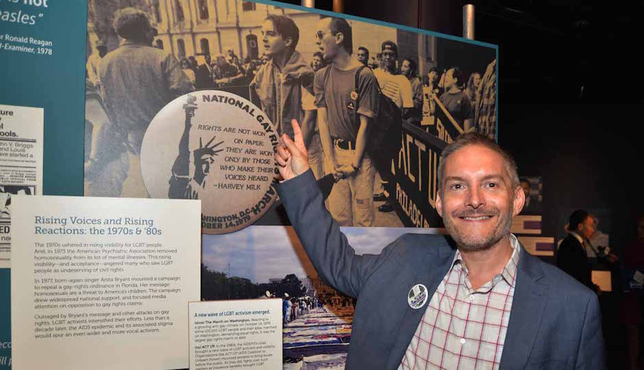 William Way Executive Director Christopher Bartlett points at his younger self in a photo of him marching with ACT-UP in 1992. | Photo by HughE Dillon