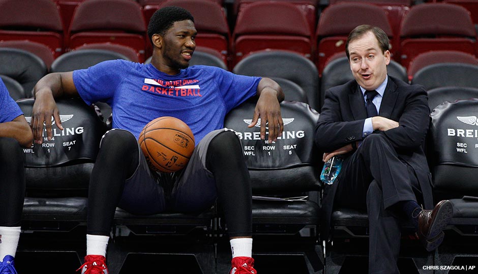 76ers general manager Sam Hinkie (right) talks with center Joel Embiid during pre-game warm-ups at the Wells Fargo Center on December 15th, 2014.
