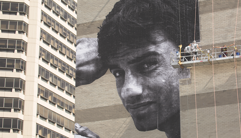 French artist JR works on his 15-story photographic creation. | Photo by Steve Weinik
