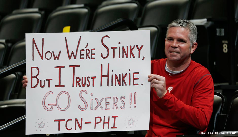 Philadelphia 76ers fan and Bucks County, Pa., native Andy Atkinson, who now lives in Denver, waves a placard in support of 76ers general manager Sam Hinkie's rebuilding effort as the Sixers take the court to face the Denver Nuggets in the first quarter of an NBA basketball game Wednesday, March 25, 2015, in Denver.