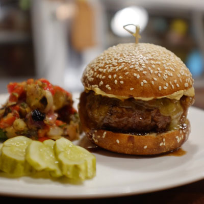 KQ Burger with raw cheddar, garlic chili aioli, served on a brioche.