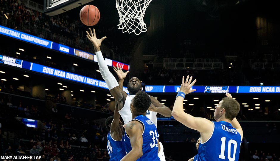 Villanova forward Daniel Ochefu, center, goes to the basket against UNC Asheville forward Sam Hughes (31) and guard Kevin Vannatta (10) during the first half of a first-round men's college basketball game in the NCAA Tournament.