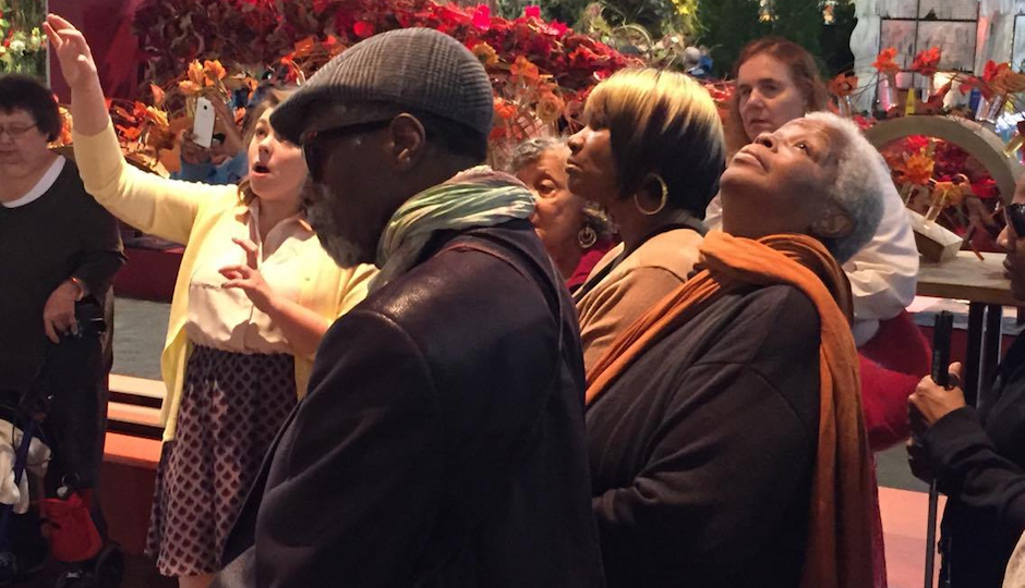West Philadelphia resident Eleanor Childs tilts her head back as Nicole Sardella describes an exhibit at the Philadelphia Flower Show.