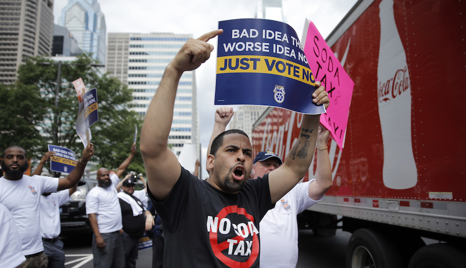 FILE - In this Wednesday, June 8, 2016 file photo, opponents of a proposed sugary drink tax demonstrate outside City Hall in Philadelphia. Philadelphia is set to become the first major American city with a soda tax despite a multimillion-dollar campaign by the beverage industry to block it. The City Council is expected to give final approval Thursday, June 16, 2016, to a 1.5 cent-per-ounce tax on sugary and diet beverages. (AP Photo/Matt Rourke, File)