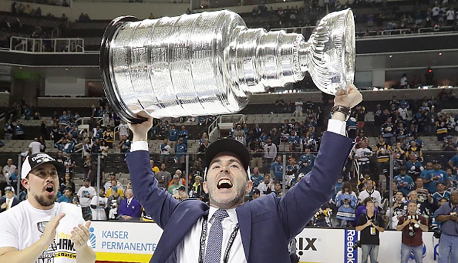 Jim Britt holds the Stanley Cup on the ice after the Penguins win