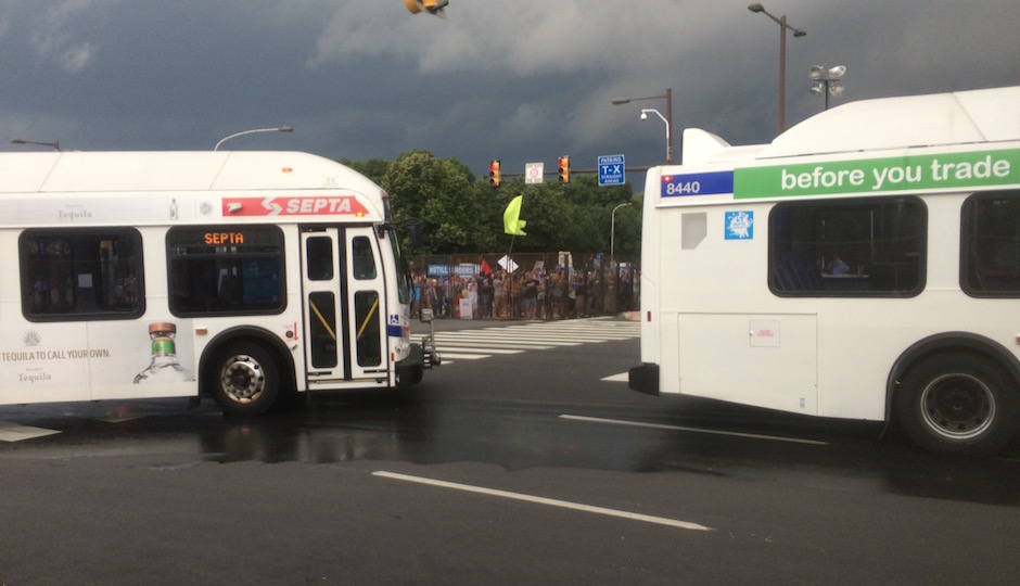 SEPTA shuttle buses, fresh from dropping off passengers, round the intersection of Broad Street and Pattison Avenue as supporters of Sen. Bernie Sanders stage a protest outside the convention security perimeter. | Photos: Sandy Smith