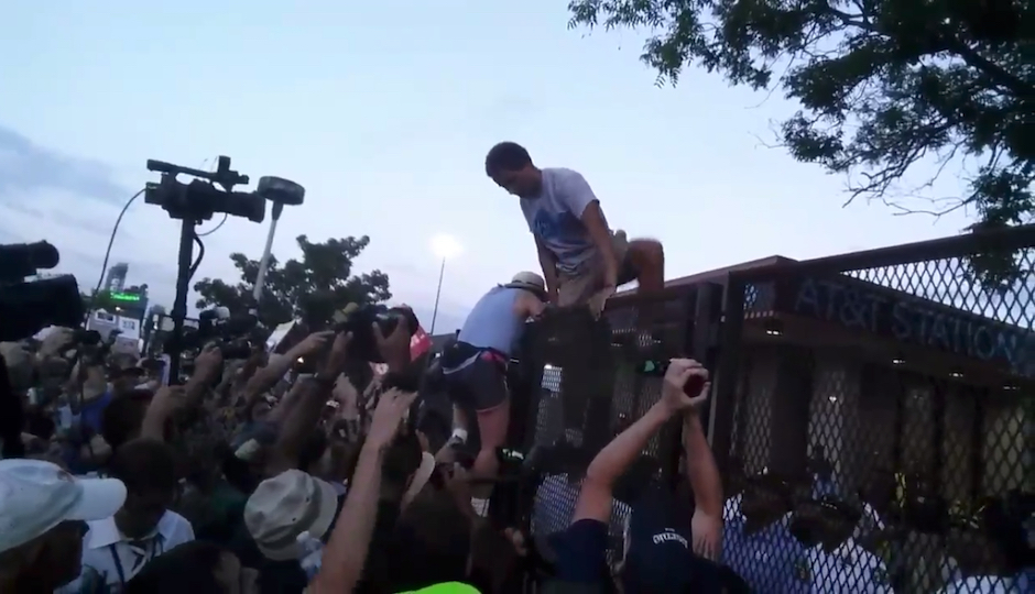 Protesters scale the DNC security fence on Tuesday, July 26th. (Photo via screenshot of video from Twitter user @rousseau_ist)