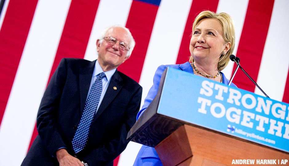 Hillary Clinton accompanied by Sen. Bernie Sanders, left, smiles while speaking as Sanders endorses Clinton at a rally at Portsmouth High School in Portsmouth, N.H., Tuesday, July 12, 2016.