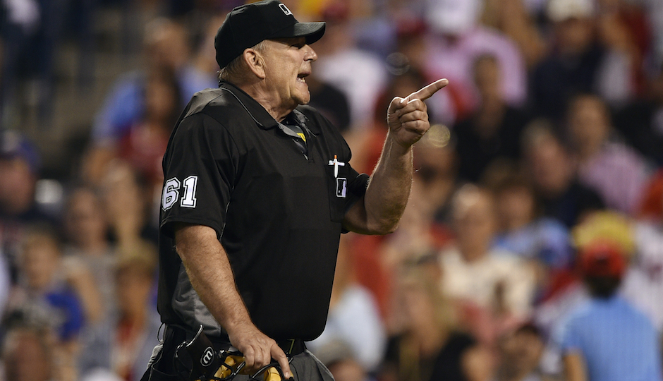 Home plate umpire Bob Davidson points into the crowd at a unruly fan during the sixth inning of a baseball game between the Philadelphia Phillies and the San Francisco Giants, Tuesday, Aug. 2, 2016, in Philadelphia. (AP Photo/Derik Hamilton)