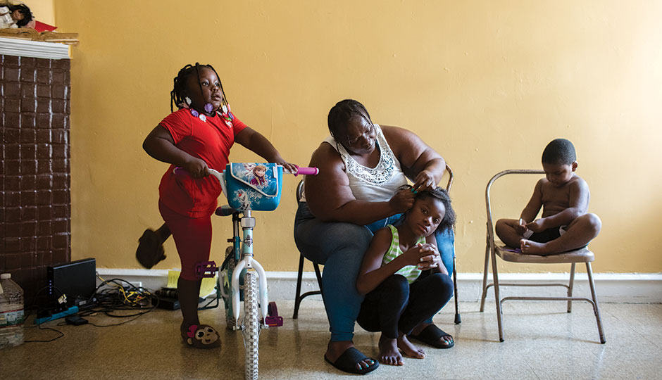 McQueen in her West Philadelphia home with three of her 13 grandchildren: left to right, Jaleehah, 5, Mayliyah, 9, and Khaalid “Booda” Casey, 4 | Photograph by Neal Santos