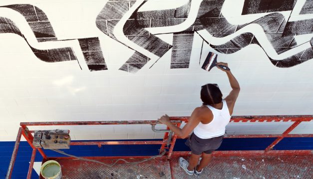 Artist Isaac Lin creating a new piece of public art at the Murals at Swanson Walk, South Philadelphia. Photo by Steve Weinik for Mural Arts Philadelphia