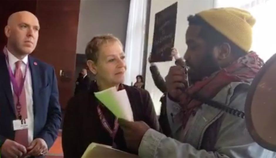 Screenshot of Abdul-Aliy Mohammad reading a list of demands to Nurit Shein and Michael Weiss.