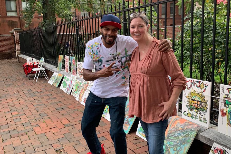 philadelphia street artist jalapeno miles with a woman who tracked him down after he left a painting in the lobby of her building