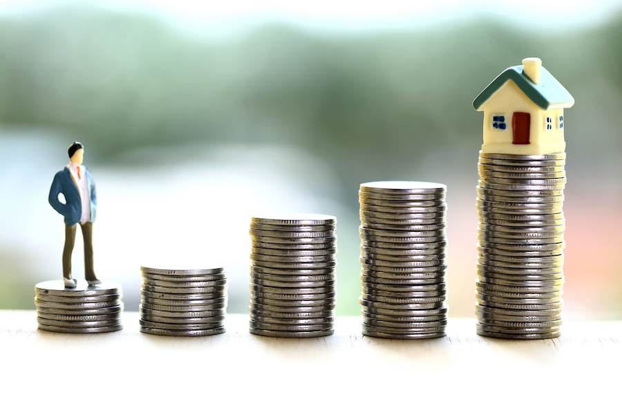 stacks of coins leading to a house