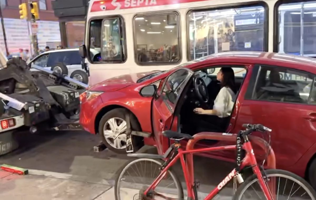 A woman and her cigarette share a moment in a car on South Street while the Philadelphia Parking Authority (PPA) was trying to tow the vehicle